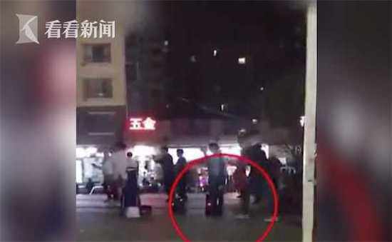 一名大妈直接从地上捡起一块砖头