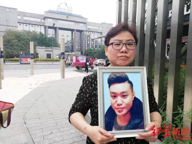 母亲陈晔抱着儿子的遗像 ,小伙劝人结账被捅身亡,家属起诉面馆老板索赔3万 一审判决:驳回起诉